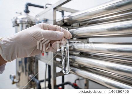 Scientist examines clear liquid in test tube at water purification plant Scientist examines clear liquid in test tube at water purification plant 140860796