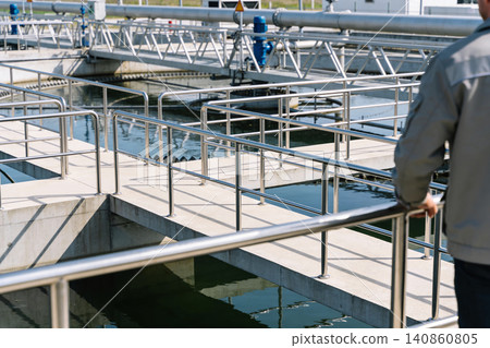 Modern wastewater treatment plant with concrete basins and metal walkways Modern wastewater treatment plant with concrete basins and metal walkways 140860805