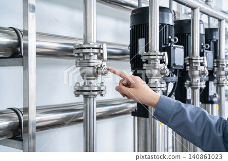 Industrial worker's hand operating a valve in a clean water processing plant Industrial worker's hand operating a valve in a clean water processing plant 140861023