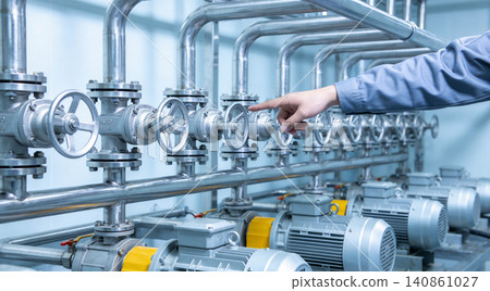 Industrial worker's hand adjusting valve in a complex pipe system with motors Industrial worker's hand adjusting valve in a complex pipe system with motors 140861027