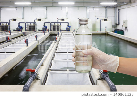 Scientist holding a sample of clear liquid in a laboratory setting Scientist holding a sample of clear liquid in a laboratory setting 140861123