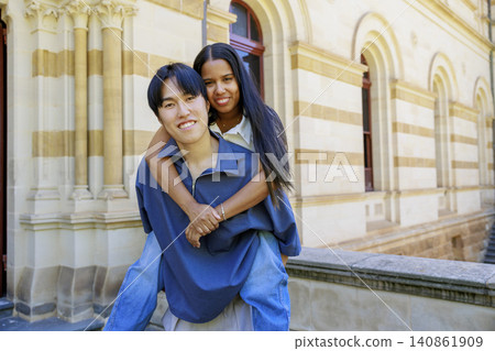 An international couple, with the man carrying her on his back and smiling. An international couple, with the man carrying her on his back and smiling. 140861909