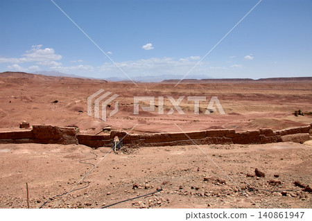 The vast red clay desert stretches out beneath the blue sky near Ait Benhaddou, Morocco. The vast red clay desert stretches out beneath the blue sky near Ait Benhaddou, Morocco. 140861947