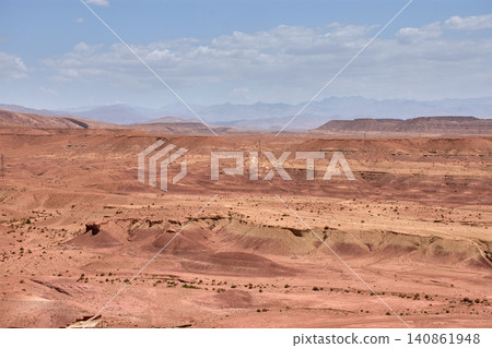 The vast red clay desert stretches out beneath the blue sky near Ait Benhaddou, Morocco. The vast red clay desert stretches out beneath the blue sky near Ait Benhaddou, Morocco. 140861948