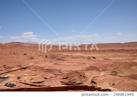 The vast red clay desert stretches out beneath the blue sky near Ait Benhaddou, Morocco. The vast red clay desert stretches out beneath the blue sky near Ait Benhaddou, Morocco. 140861949