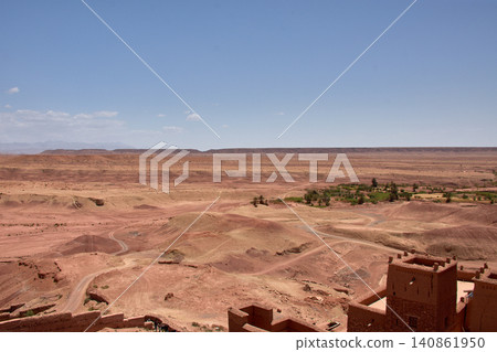 The vast red clay desert stretches out beneath the blue sky near Ait Benhaddou, Morocco. 140861950