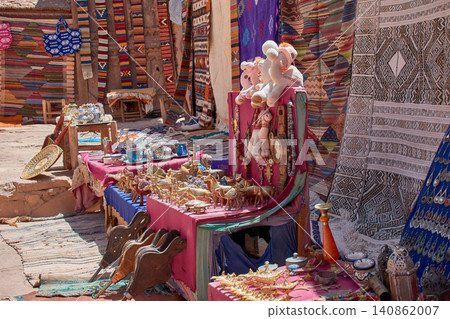 Various bronze figures and Berber rugs decorate a souvenir stall in Ouarzazate, Morocco. Various bronze figures and Berber rugs decorate a souvenir stall in Ouarzazate, Morocco. 140862007