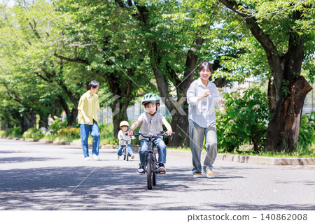 Children and their parents riding bicycles in the park Children and their parents riding bicycles in the park 140862008