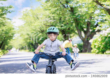 A young elementary school boy playing energetically on his bicycle. A young elementary school boy playing energetically on his bicycle. 140862009