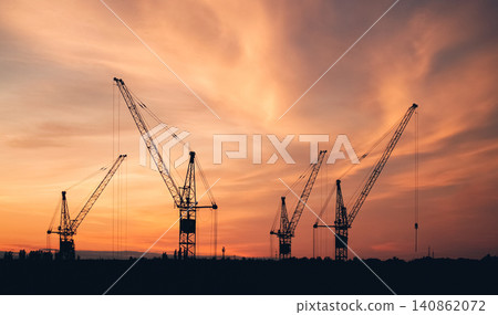 Construction cranes silhouette at sunset sky, industrial landscape with copy space 140862072