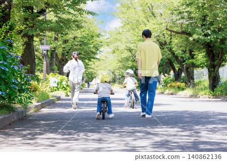 Children and their parents riding bicycles in the park Children and their parents riding bicycles in the park 140862136