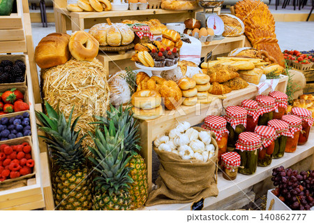 Stalls filled with bread, fruits, veggies attract visitors to rural local market in late morning. Stalls filled with bread, fruits, veggies attract visitors to rural local market in late morning. 140862777