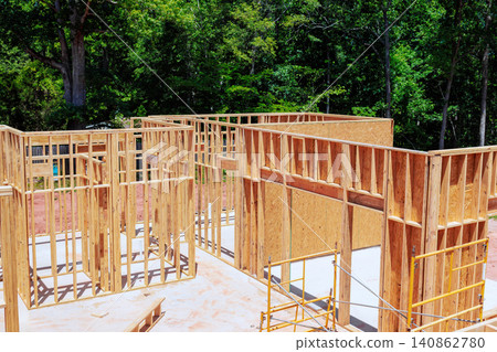 Workers build wooden beams frames for structure framing stage unfinished house Workers build wooden beams frames for structure framing stage unfinished house 140862780
