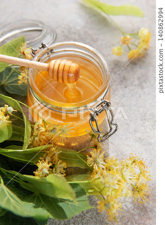 Linden honey jar with dipper and blossoms Linden honey jar with dipper and blossoms 140862994