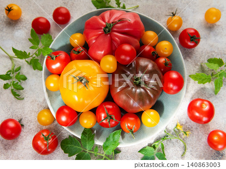 Fresh farm tomatoes displaying colorful variety on a plate Fresh farm tomatoes displaying colorful variety on a plate 140863003