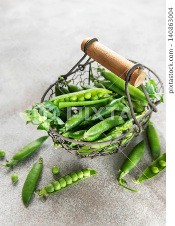 Fresh green peas pods in metal basket harvesting concept Fresh green peas pods in metal basket harvesting concept 140863004