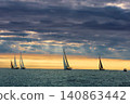 A lot of sailing boats are in sailing regatta in the Gulf of Finland at sunset, Russia, St.Petersburg, hot race of several yachts, teamwork, yachtsman 140863442