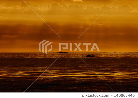 incredible reflection on the water at sunset, Yachtsmen are sitting amicably on board the boat, sailing boat is in sailing regatta in the Gulf of Finland at sunset, hot race, teamwork 140863446