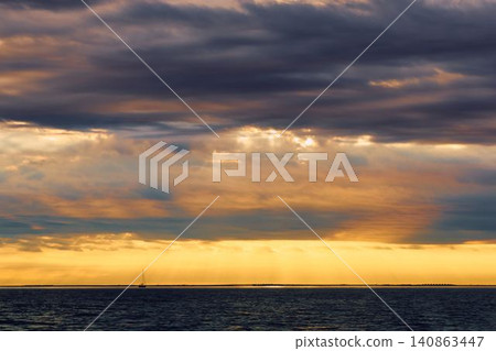 incredible reflection on the water at sunset, Yachtsmen are sitting amicably on board the boat, sailing boat is in sailing regatta in the Gulf of Finland at sunset, hot race, teamwork incredible reflection on the water at sunset, Yachtsmen are sitting amicably on board the boat, sailing boat is in sailing regatta in the Gulf of Finland at sunset, hot race, teamwork 140863447