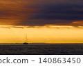 incredible reflection on the water at sunset, Yachtsmen are sitting amicably on board the boat, sailing boat is in sailing regatta in the Gulf of Finland at sunset, hot race, teamwork 140863450