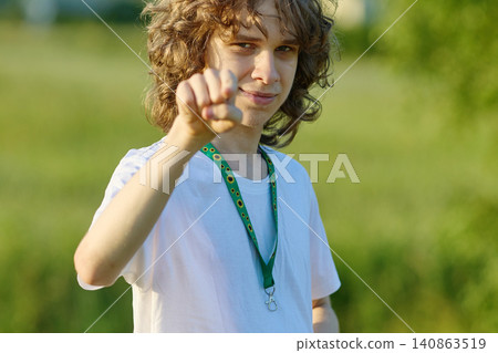 Young man pointing finger gesture wearing sunflower lanyard Young man pointing finger gesture wearing sunflower lanyard 140863519