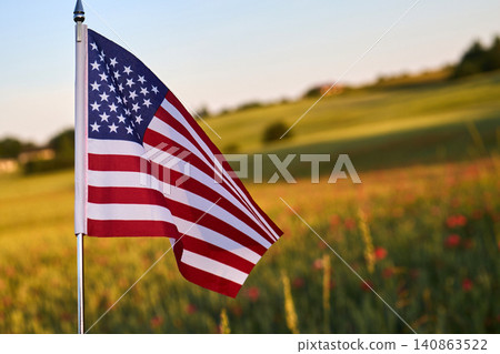 American flag waving in rural field during sunset 140863522