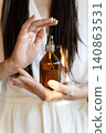 Amber Cosmetic Bottle In Woman Hands, Premium Beauty Advertising Concept For Hair Care, Skincare And Self Care 140863531