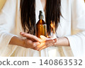 Amber Cosmetic Bottle In Woman's Hands, Beauty Advertising Concept For Hair Care, Skincare, Self Care, Premium Cosmetics And Home Wellness Lifestyle 140863532