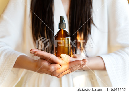 Amber Cosmetic Bottle In Woman's Hands, Beauty Advertising Concept For Hair Care, Skincare, Self Care, Premium Cosmetics And Home Wellness Lifestyle Amber Cosmetic Bottle In Woman's Hands, Beauty Advertising Concept For Hair Care, Skincare, Self Care, Premium Cosmetics And Home Wellness Lifestyle 140863532