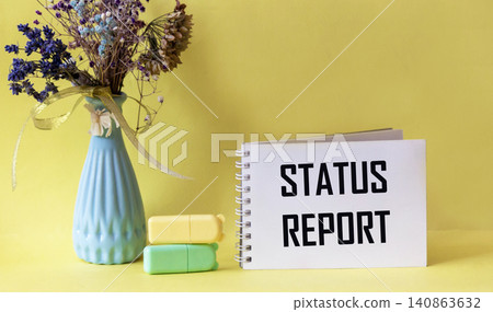 A notebook with the words STATUS REPORT on a yellow background A notebook with the words STATUS REPORT on a yellow background 140863632