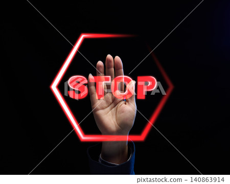 Raised female palm behind glowing red neon STOP sign Raised female palm behind glowing red neon STOP sign 140863914
