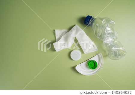 Plastic waste items on green background with copy space, recycling and environmental pollution concept 140864022