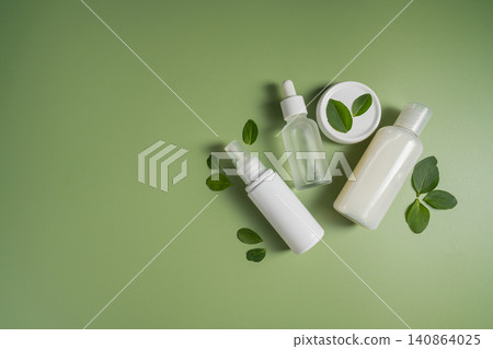 Natural skincare products with botanical leaves on green background, minimalist clean beauty mockup Natural skincare products with botanical leaves on green background, minimalist clean beauty mockup 140864025