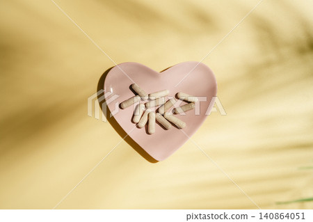 Collagen supplement capsules on yellow background with leaf shadows, flat lay and copy space Collagen supplement capsules on yellow background with leaf shadows, flat lay and copy space 140864051