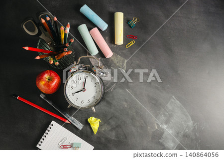 Blackboard workspace with school supplies and alarm clock, education background, back to school concept Blackboard workspace with school supplies and alarm clock, education background, back to school concept 140864056