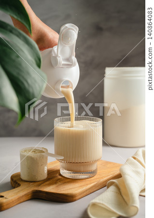 Pouring vanilla protein shake into glass, sports nutrition supplement and healthy lifestyle Pouring vanilla protein shake into glass, sports nutrition supplement and healthy lifestyle 140864083