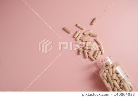 Collagen supplement capsules spilling from bottle on pink background with copy space, feminine food supplement abstract background Collagen supplement capsules spilling from bottle on pink background with copy space, feminine food supplement abstract background 140864088