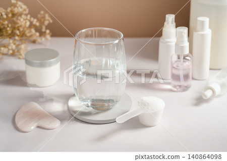 Collagen powder scoop beside glass of water and skincare products Collagen powder scoop beside glass of water and skincare products 140864098