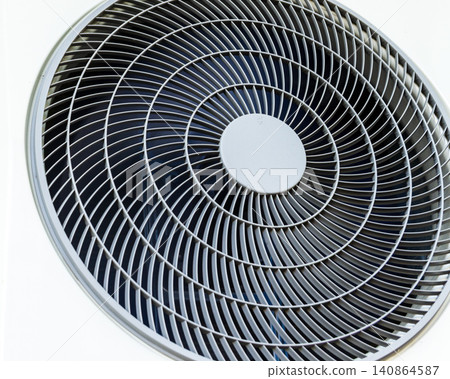 Close-up abstract view of a modern round air conditioner ventilation grille and cooling fan unit. Close-up abstract view of a modern round air conditioner ventilation grille and cooling fan unit. 140864587