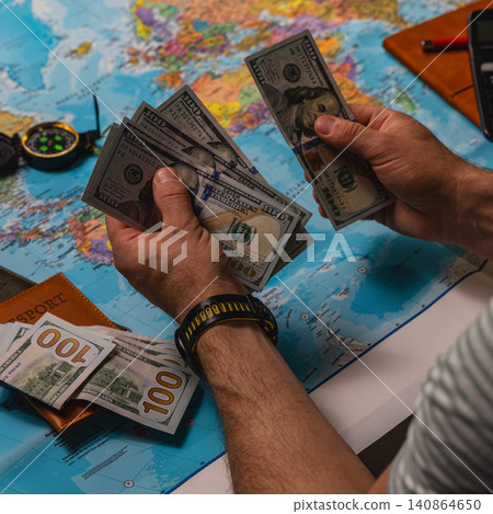 Counting cash and planning travel expenses with a world map Counting cash and planning travel expenses with a world map 140864650