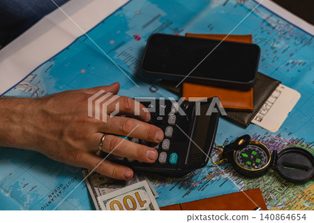 Budget calculation using calculator on a world map with travel items Budget calculation using calculator on a world map with travel items 140864654