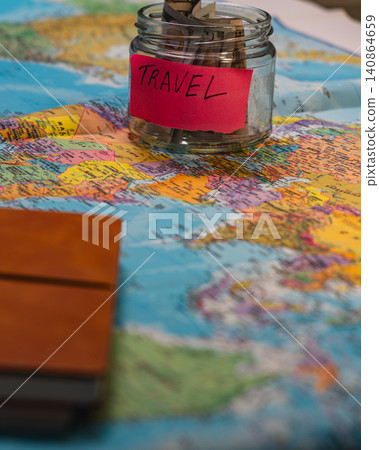 Start a travel fund with savings jar on a world map for future trips Start a travel fund with savings jar on a world map for future trips 140864659