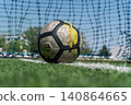 Soccer ball on white line of green grass field near goal ne 140864665