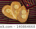 Traditional Turkmen flatbread chorek on national striped fabric background 140864668