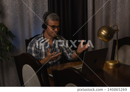 Freelancer working at home during an online meeting at night Freelancer working at home during an online meeting at night 140865269