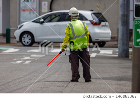 Traffic controllers holding red sticks to direct traffic. Traffic controllers holding red sticks to direct traffic. 140865362