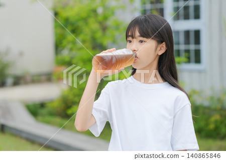 一個女孩用塑膠瓶喝大麥茶。 140865846