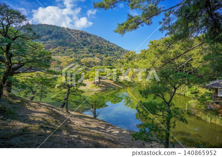 Ritsurin Garden, a traditional Japanese daimyo garden, features a beautiful pond and pine trees. Ritsurin Garden, a traditional Japanese daimyo garden, features a beautiful pond and pine trees. 140865952