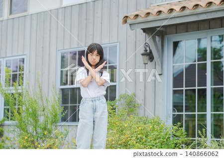 A little girl in elementary school makes an "X" sign. A little girl in elementary school makes an "X" sign. 140866062