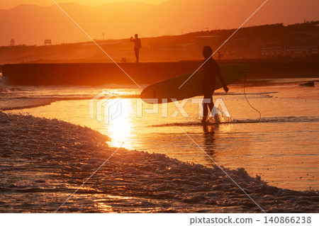 Surfers heading towards Lake Nakaumi at sunset on Kugenuma Beach, Shonan. Surfers heading towards Lake Nakaumi at sunset on Kugenuma Beach, Shonan. 140866238